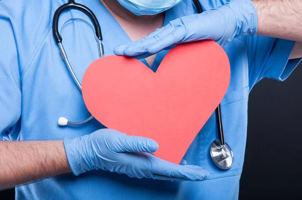 Close-up de cardiologista usando esfregaços segurando forma de coração vermelho — Fotografia de Stock