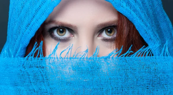 Sensual eyes of mysterious woman behind scarf