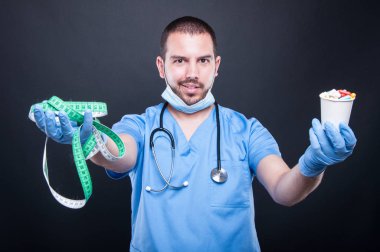 Plastik cerrah giyen ölçüm bandı ve hapları tutan scrubs