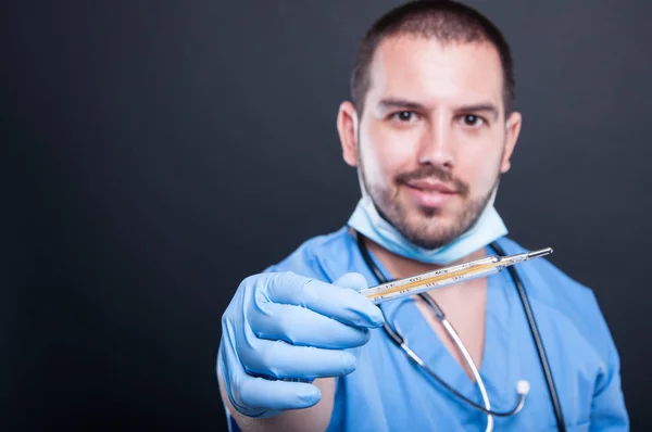 Selective focus of doctor wearing scrubs showing thermometer — Stock Photo, Image