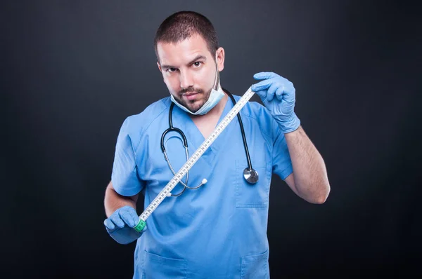 Plastický chirurg nošení drhne zobrazeno měřicí páska — Stock fotografie