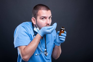 Şişeden hap alarak önlük giyen doktor 