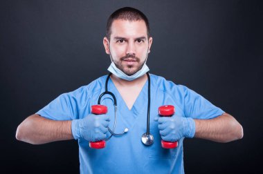 Plastik dumbbells ile egzersiz yapma ve gülümseyen cerrah