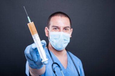 Şırınga gösterilen önlük giyen doktor seçici odak