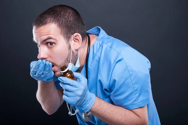 Doutor vestindo esfrega tomar pílulas de garrafa como se escondendo — Fotografia de Stock