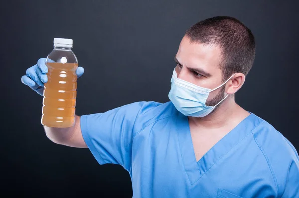 Medic wearing face mask holding not drinkable water — Stock Photo, Image