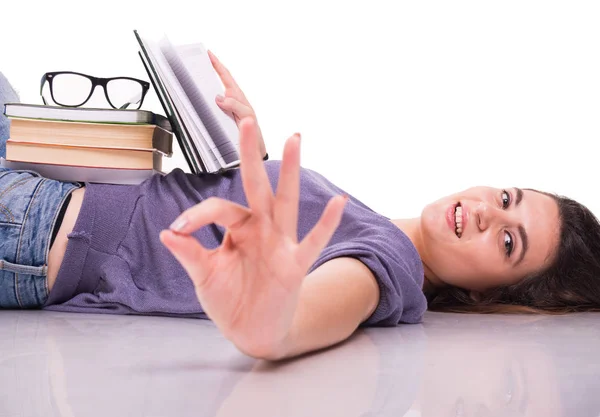 Chica tendida en el suelo mientras lee libros — Foto de Stock