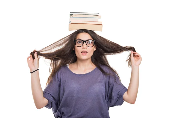 Smart college student balancing books on hea — Stock Photo, Image