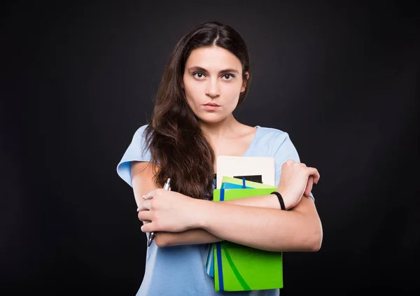 Serieuze student holding haar college lezingsboeken — Stockfoto