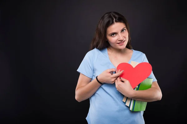 Cute student girl holding card for Valentine day — Stock Photo, Image