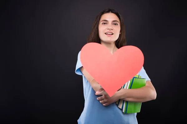 Beautiful teenage woman holding paper heart — Stock Photo, Image