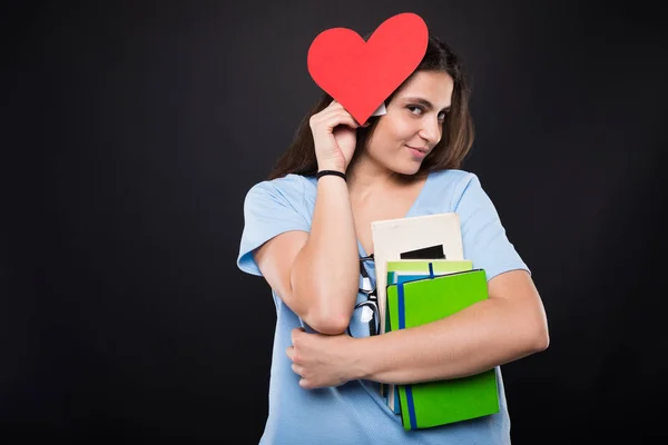 Pretty young college girl holding red paper heart — Stock Photo, Image