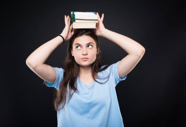 Kitap kafasına yığını tutan genç üniversite öğrencisi