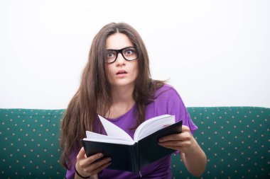 Kitap koltukta oturan şok genç kadın 