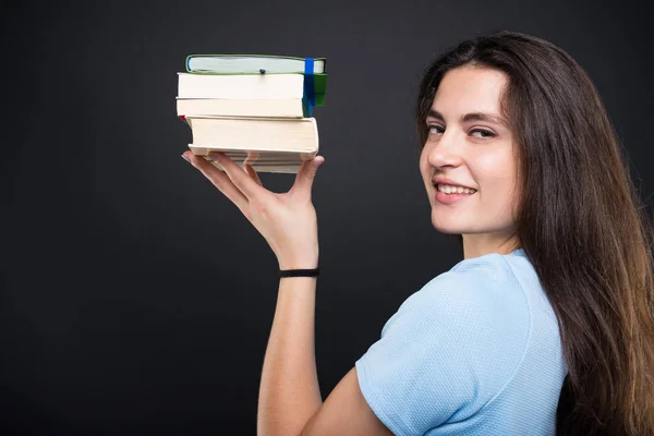 Chica estudiante sonriente sosteniendo algunos libros — Foto de Stock