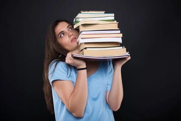 Bezorgd student meisje houdt van een stapel boeken — Stockfoto