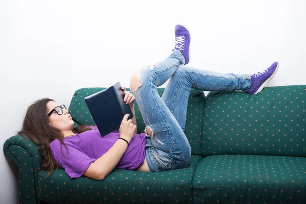 Attraente ragazza lettura libro di fiabe sul divano a casa — Foto Stock