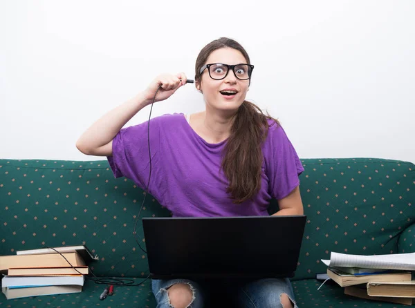 Funny woman sitting on the couch with laptop — Stock Photo, Image