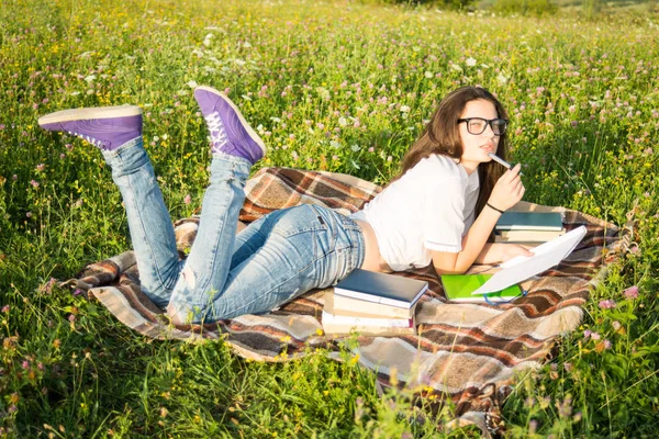 Young girl with book outside in summer day