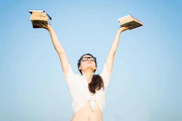 Chica levantando brazos con libros en el aire — Foto de Stock