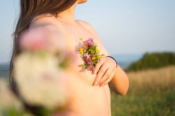 Fille nue dehors tenant des fleurs — Photo