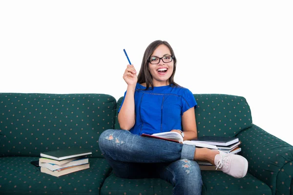 Student girl sitting on couch holding pen like good idea — Stock Photo, Image