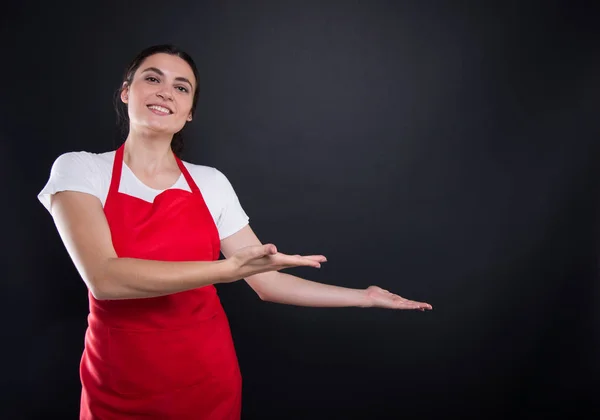 Mulher feliz com avental vermelho convidando você em — Fotografia de Stock