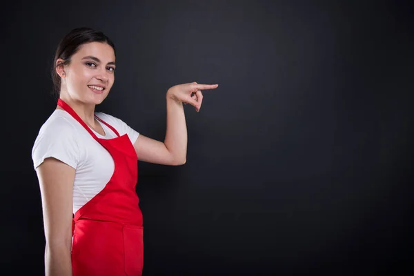 Vendedor menina atraente apontando com o dedo — Fotografia de Stock