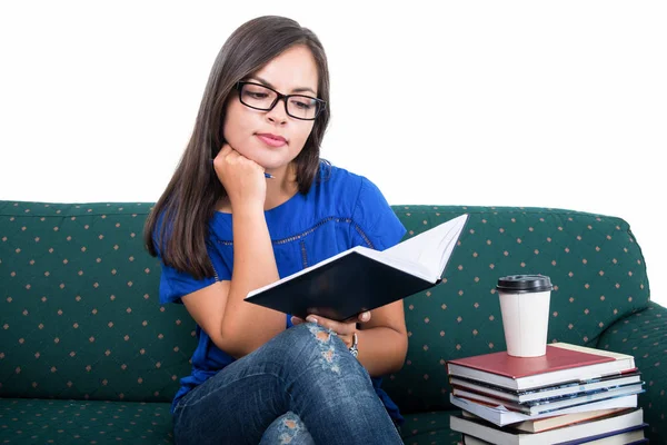 Studentin sitzt auf Couch und liest aus Notizbuch — Stockfoto