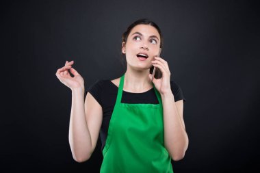 Süpermarket satıcı bir akıllı telefon kullanarak önlük ile