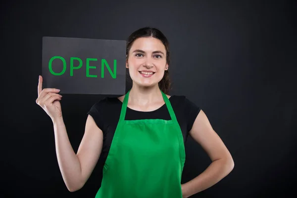 Friendly woman employee holding card with text