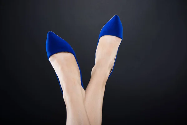 Closeup της γυναικείας σταυρωμένα πόδια με τα μπλε τακούνια — Φωτογραφία Αρχείου