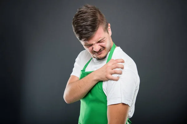 Portrét supermarketu zaměstnavatel drží rameno jako v bolesti — Stock fotografie