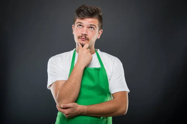 Portret van aantrekkelijke supermarkt werkgever poseren als denken — Stockfoto