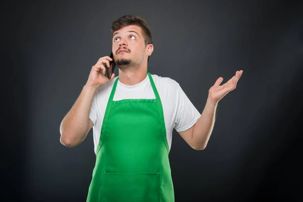 Portret supermarkt werkgever uit te leggen iets op telefoon — Stockfoto