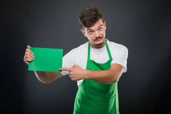 Retrato empleador de supermercado señalando cartón verde — Foto de Stock