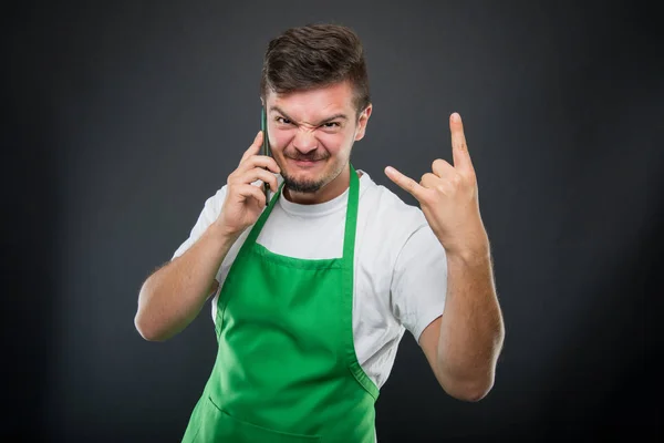 Supermarket zaměstnavatel mluvit na telefonu zobrazeno rock na gesto — Stock fotografie