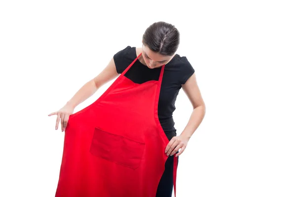 Jovem morena vendedor colocando avental vermelho em — Fotografia de Stock