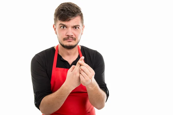Mannelijke supermarkt werkgever houdt vinger als kwetsen — Stockfoto
