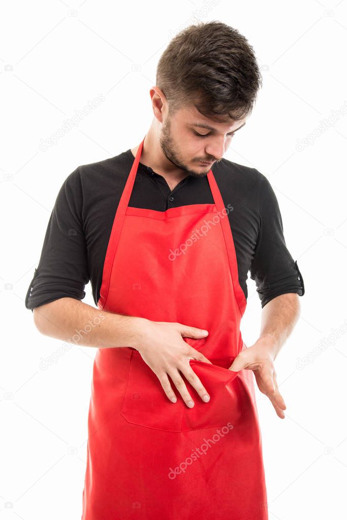 Male supermarket employer looking in his apron pocket