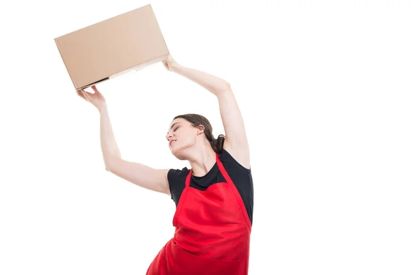 Relaxed girl employee holding up a box — Stock Photo, Image