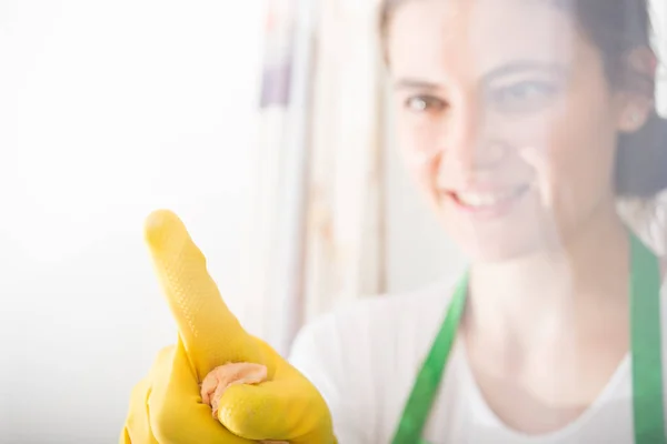 Chica ama de llaves revisando la ventana en busca de manchas — Foto de Stock