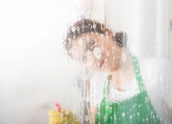 Femme de ménage nettoyage fenêtre avec spray — Photo