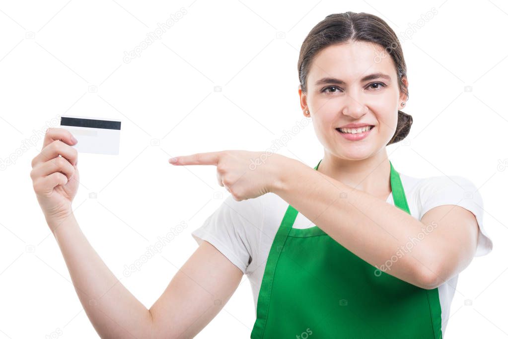 Smiling friendly saleswoman pointing to credit card