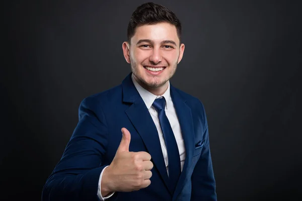 Sorridente giovane uomo d'affari tenendo il pollice in alto — Foto Stock