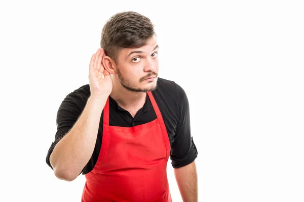 Работодатель мужского супермаркета показывает ухо, как не слышит — стоковое фото