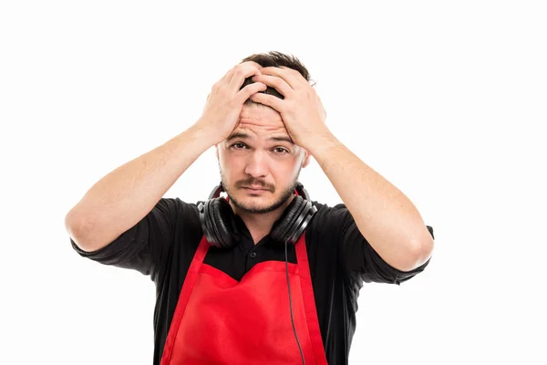 Male supermarket employer holding head wearing headphones — Stock Fotó