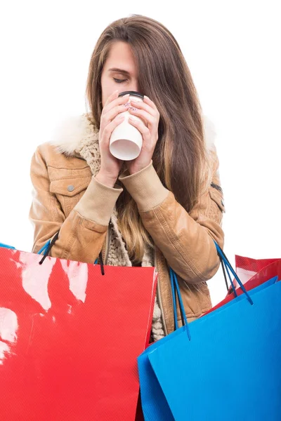 Attraktives Mädchen mit Einkaufstaschen und warmem Getränk — Stockfoto