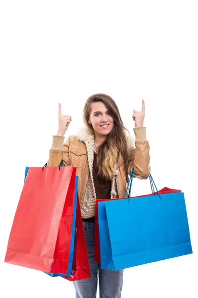 Mosolygó nő gazdaság bevásárló táskák, és felfelé mutató — Stock Fotó