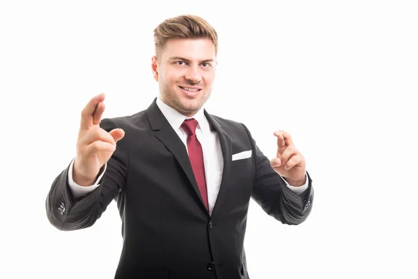 Hombre de negocios guapo sonriendo de pie con los dedos cruzados —  Fotos de Stock